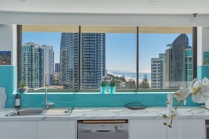 Cozinha moderna com uma grande janela com vista para a cidade e para a praia.