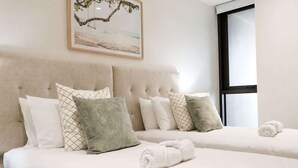 A hotel room with two beds, a large window, and a painting on the wall. - 2BR Ocean Views Pool Gym Sauna (Mermaid Beach)