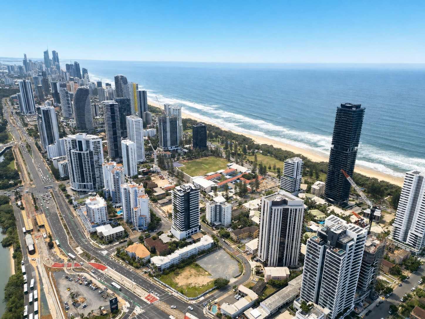 Un paysage urbain côtier avec de hauts immeubles, une plage et un ciel dégag é.