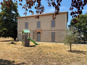 A building with a play area, including a slide and climbing structure, in front of a stone wall with windows. - Domaine des Brunis - Large, charming home with a private pool (Nègrepelisse)