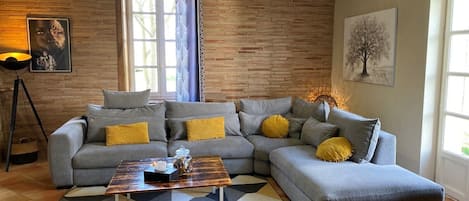 A modern living room with a grey sectional sofa, a coffee table, and a patterned rug.