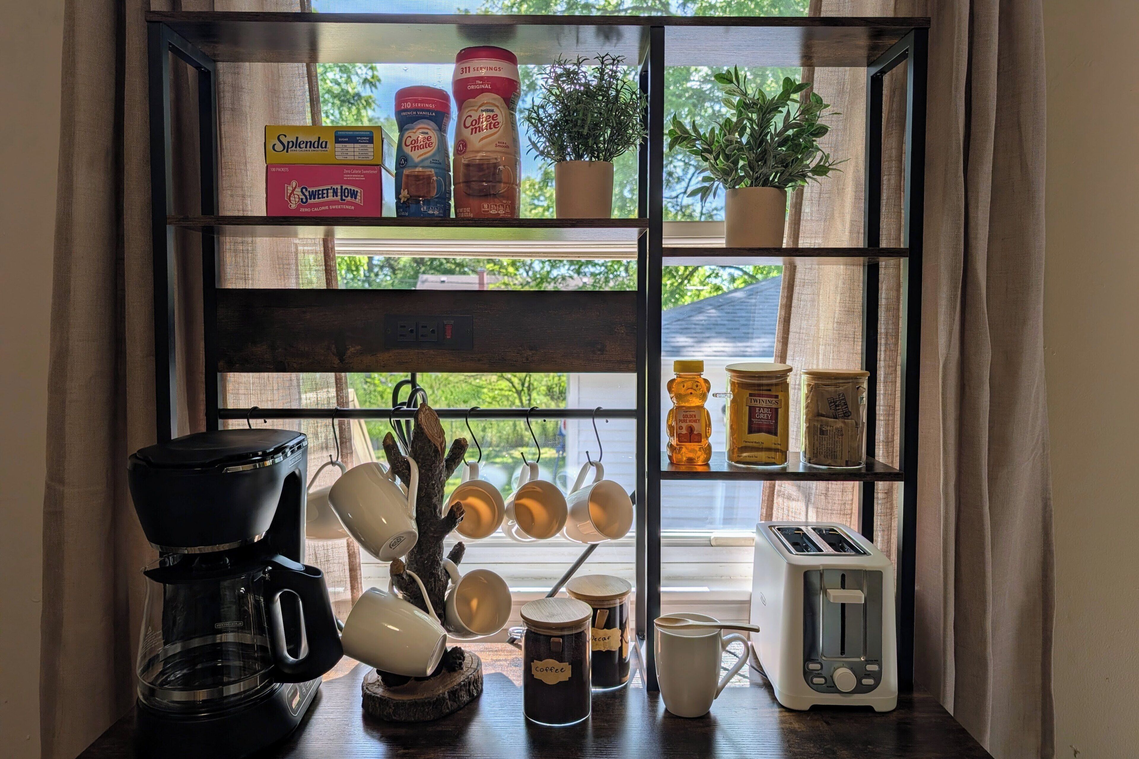 Eine Küchenarbeitsplatte mit Kaffeemaschine, Tassen und Toaster.
