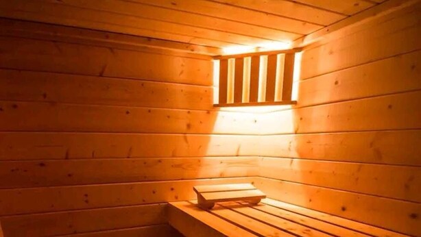 Una sauna con bancos de madera y calentador.