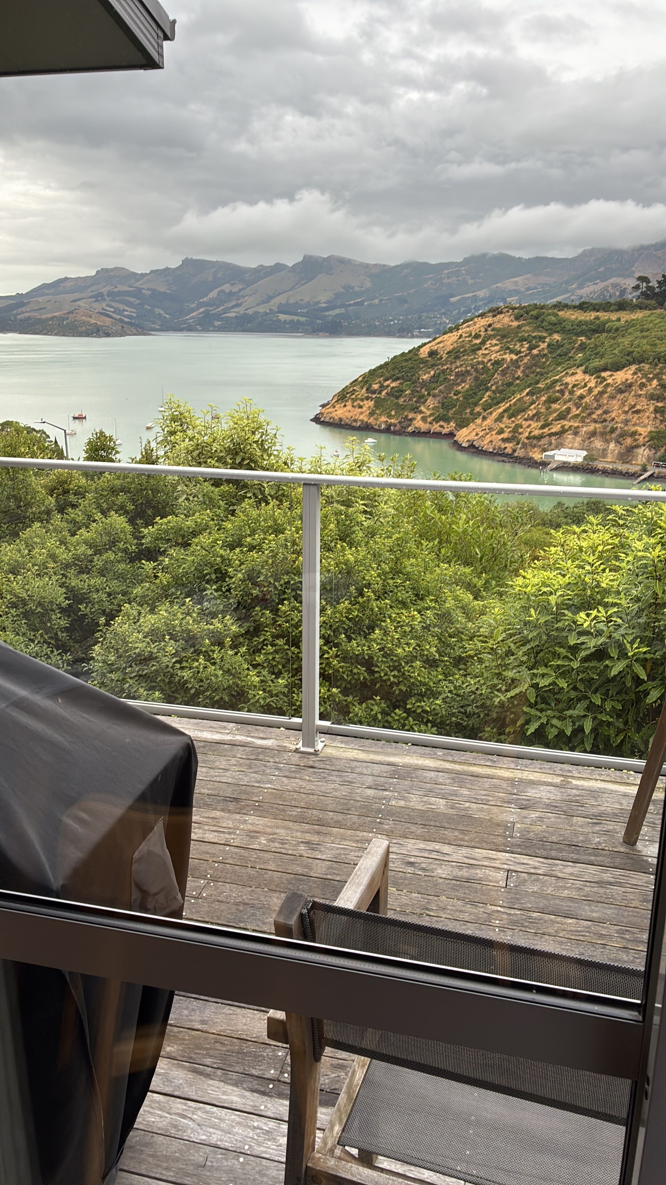 Un balcon avec vue sur un lac et des collines.