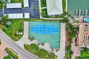 An aerial view of a sports complex with a tennis court, parking area, and surrounding greenery. - Top-Floor Coastal Escape | Bay Views | Naples Retreat (Naples)