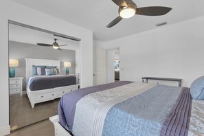 A bedroom with a bed, a ceiling fan, a nightstand, and a dresser. - Top-Floor Coastal Escape | Bay Views | Naples Retreat (Naples)