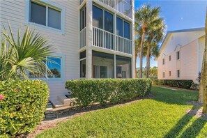 A multi-story residential building with a well-maintained lawn and palm trees. - Indian River Plantation beautiful condo on Hutchinson Island  steps to the beach (Stuart)