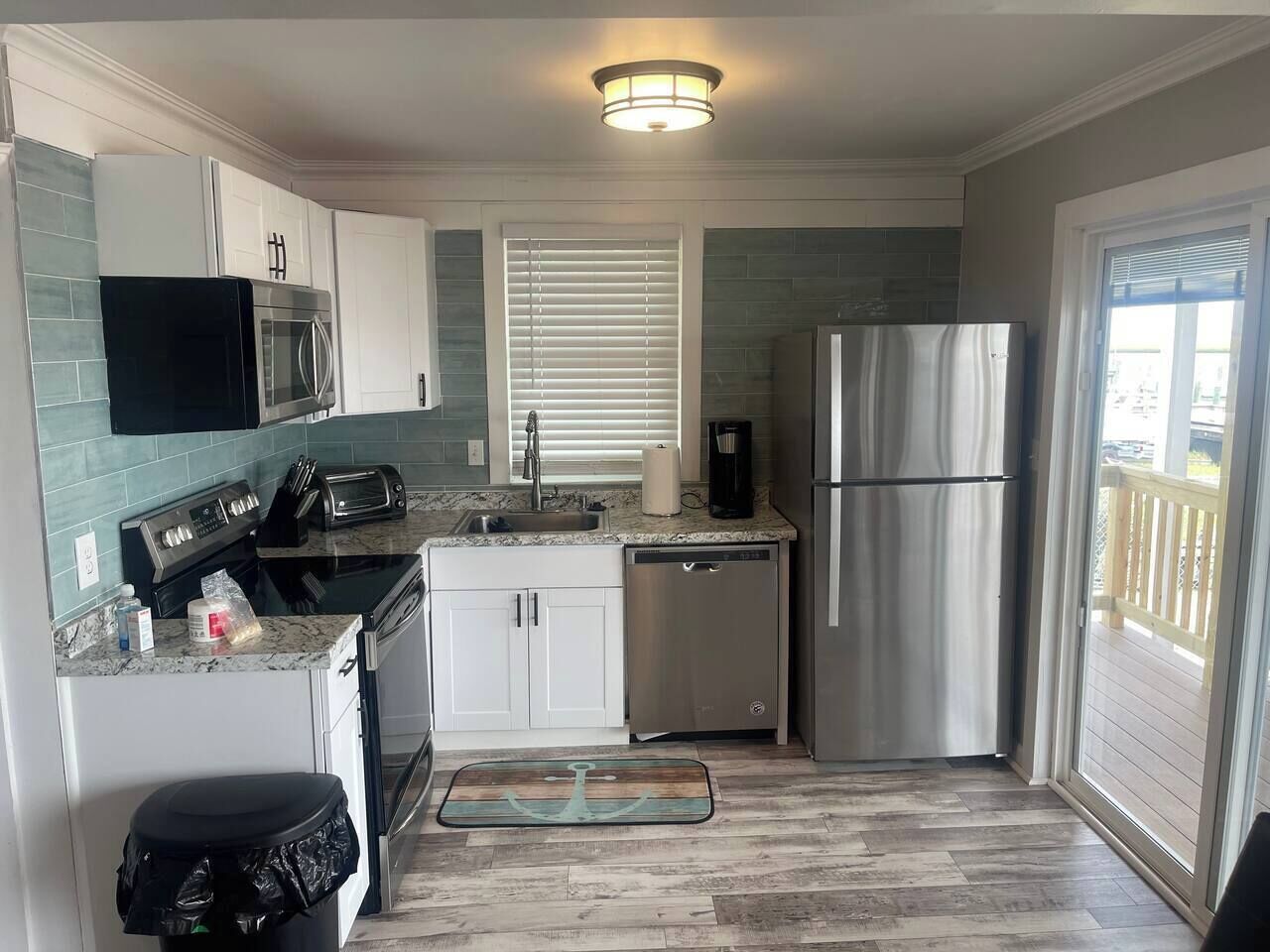 Cocina compacta con microondas, tostadora, cafetera y refrigerador.