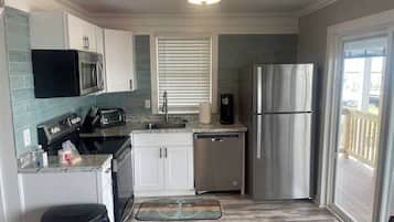 Cocina compacta con microondas, tostadora, cafetera y refrigerador.