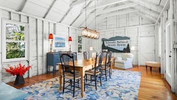 A dining area with a wooden table, chairs, and a blue patterned rug.