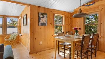 Un interior de madera con una mesa de comedor, sillas y una lámpara colgante.