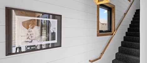 A staircase with a wooden handrail leading to a landing.