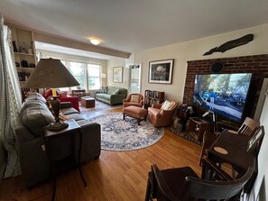A living room with a television, sofas, a coffee table, and a fireplace. - One Atlantic 5BR Harbor View Maine Home, Close to Town, Deck (Boothbay Harbor)