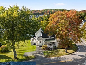 A residential area with a house featuring a porch and a driveway. - One Atlantic 5BR Harbor View Maine Home, Close to Town, Deck (Boothbay Harbor)