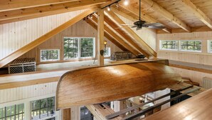 A wooden interior with a boat, wooden beams, and windows. - The Boathouse (Bath)