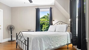 A bedroom with a bed, a standing fan, and a window with curtains. - La Maisonette - Historic Renovated 6 BR Downtown Bar Harbor (Bar Harbor)