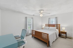A bedroom with a bed, a desk, a chair, a ceiling fan, and two bedside lamps. - 4-bedroom house in lovely Narragansett with cool ocean breeze (Narragansett)