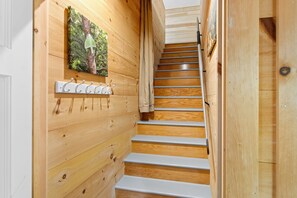 Eine Holztreppe mit Metallgeländer und einem an der Wand befestigten Kleiderhaken.