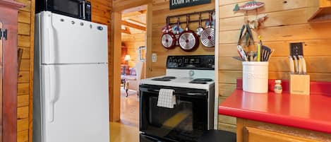 Eine Küche mit Kühlschrank, Herd und verschiedenen Küchengeräten.
