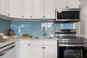 A kitchen with white cabinets, a stainless steel range hood, a microwave, and a built-in oven. - Hilton Head Beach & Tennis Resort , Oceanfront, Tennis, Restaurants, Pickleball! (Hilton Head Island)