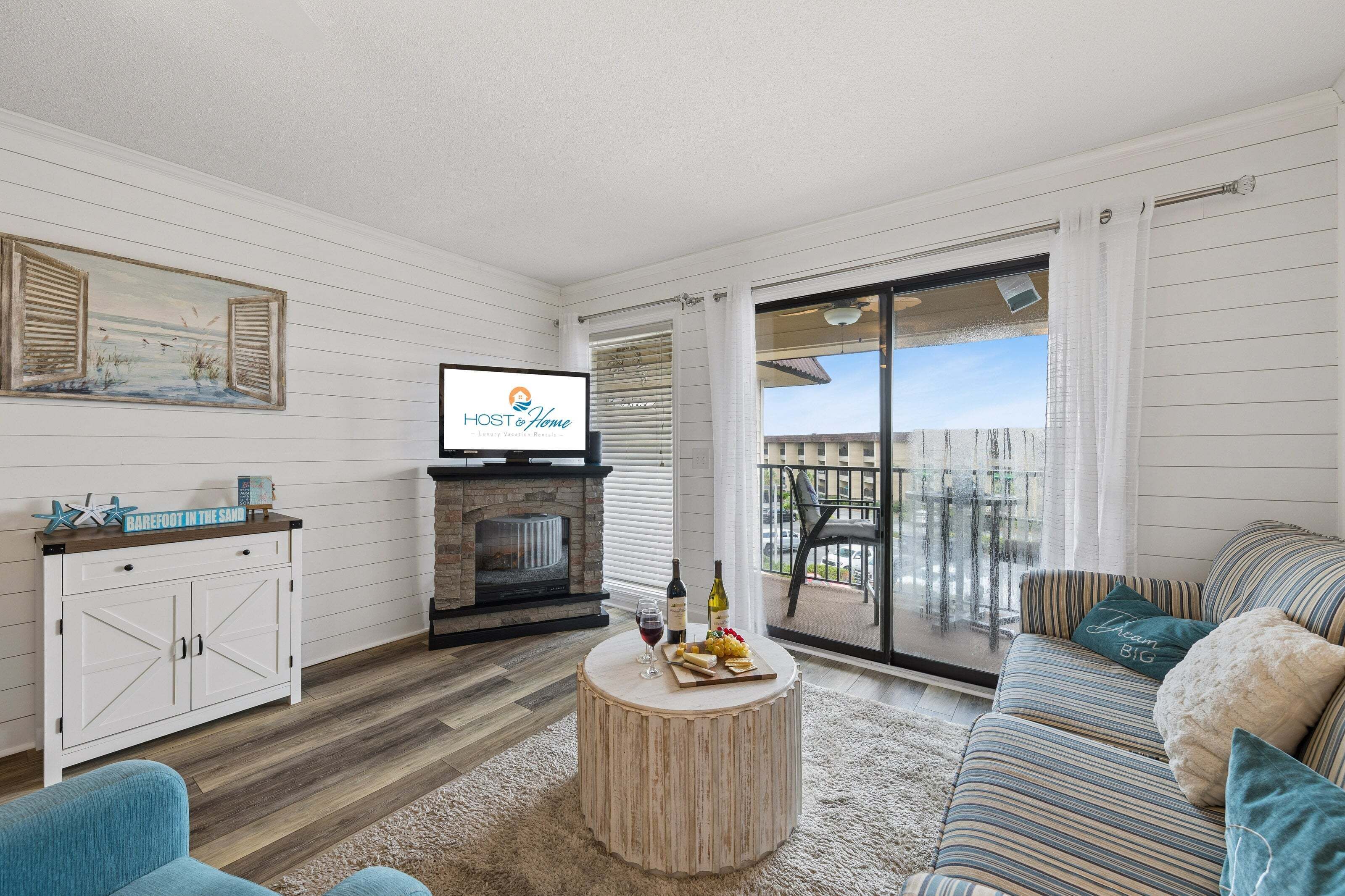 Una sala de estar acogedora con chimenea, televisor y vistas al exterior.