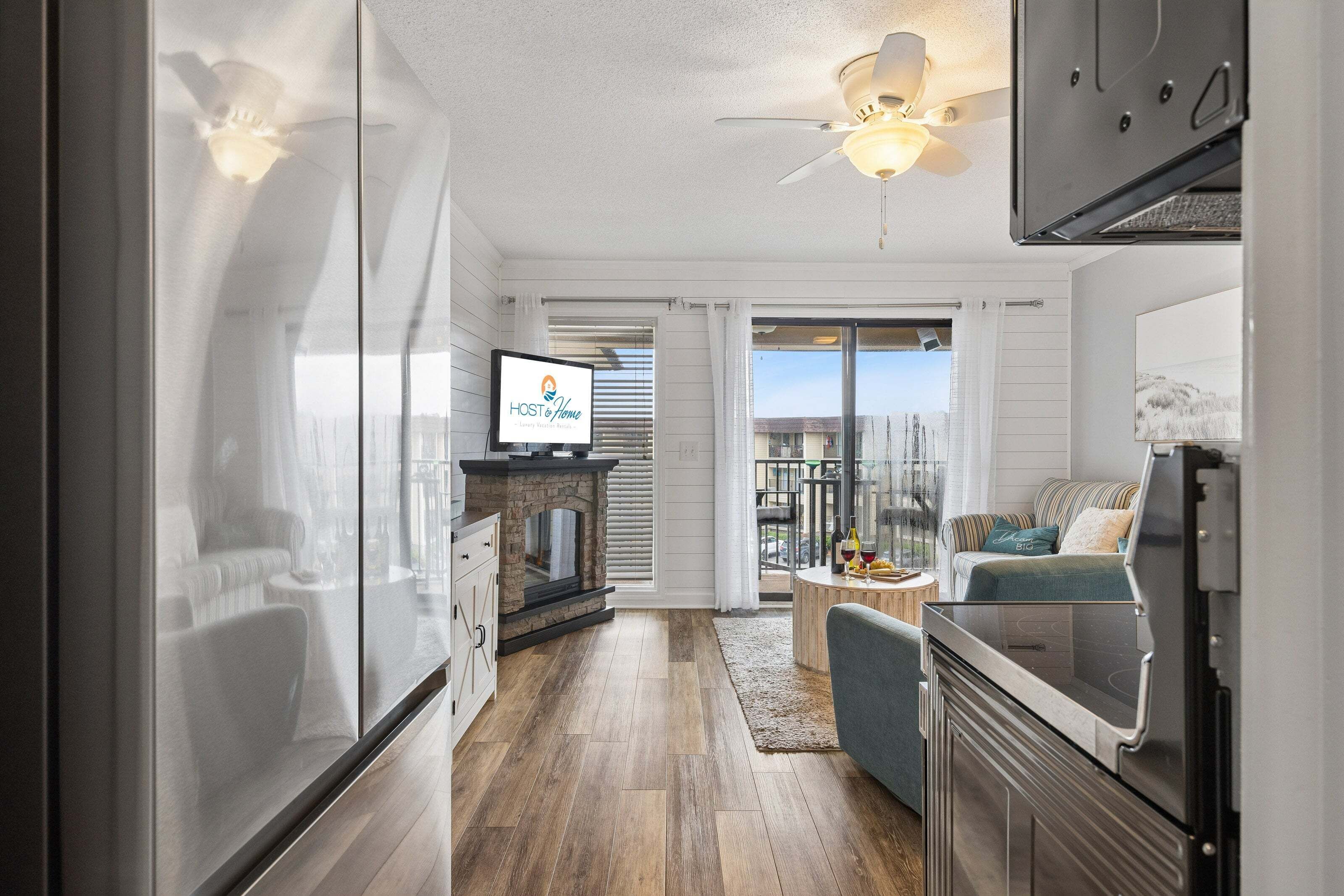Eine moderne Küche mit Backofen, ein Essbereich mit Tisch und Stühlen sowie ein Wohnzimmer mit Sofa und Fernseher.
