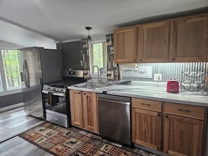 Una cocina moderna con electrodomésticos de acero inoxidable, armarios de madera y un tapete de estilo rústico.