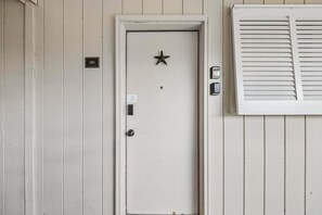 Une porte ornée d’une étoile, dotée d’un clavier pour ouvrir et fermer à clé, et sur laquelle est apposée une petite plaque.