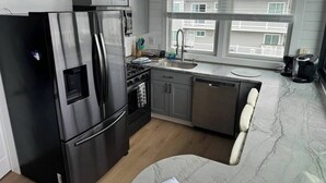 A modern kitchen with a stainless steel refrigerator, a dishwasher, and a sink. - Bayfront! 2 BR/2 BA Upper condo [2nd/top floor]- Spectacular Bay view! [no dogs] (Brigantine)