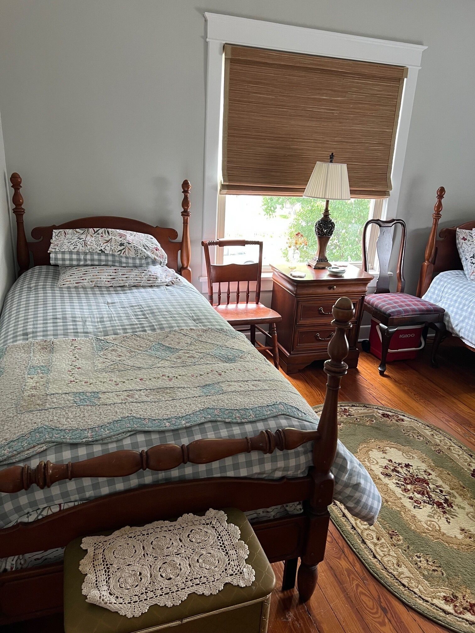 A bedroom with a bed, a dresser, a chair, a nightstand, and a window with blinds.