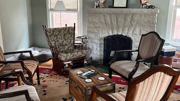 A living room with a fireplace, multiple chairs, a coffee table, and a decorative wreath.