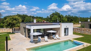 A modern house with a swimming pool, outdoor seating, and a stone wall. - Villa Luen (Istria - Cukrići) (Cukrići)