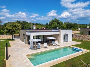 A modern house with a swimming pool, outdoor seating, and a stone wall. - Villa Luen (Istria - Cukrići) (Cukrići)