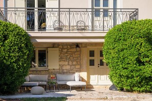 A two-story building with a balcony, stone walls, a sofa, and a table with glasses. - Villa Casa Abete (Istria - Svetvinčenat) (Svetvinčenat)