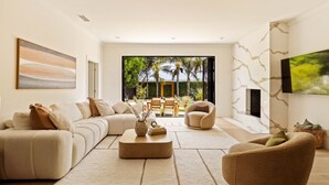 A modern living room with a sectional sofa, a coffee table, and a fireplace.