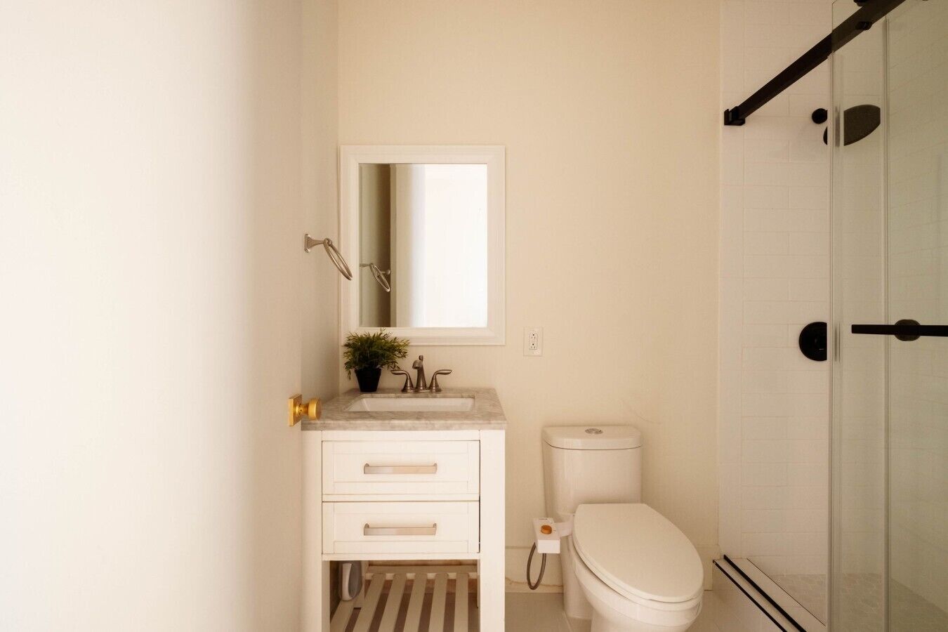 Un baño con lavamanos, espejo y retrete blancos.