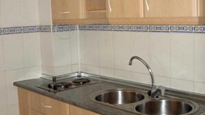 Una cocina con dos fregaderos, una estufa y armarios de madera.
