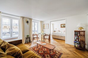 Uma sala de estar moderna com um sofá, uma mesa de centro e um espaço de jantar com cadeiras e uma mesa.