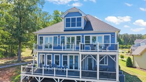 A two-story house with a balcony and large windows. - MAIN-LAKE VIEWS Boat Slip + Community Pool-Golf Cart-Sleeps 12 (Littleton)