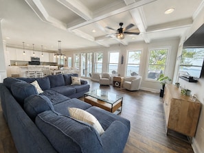 A spacious living room with a sectional sofa, a coffee table, and a television. - MAIN-LAKE VIEWS Boat Slip + Community Pool-Golf Cart-Sleeps 12 (Littleton)