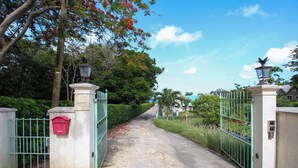 A gated driveway leading to a property with a mailbox and a lamp post. - Cowrie Cottage | Private Pool | Near Gibbes Beach (Gibbes)