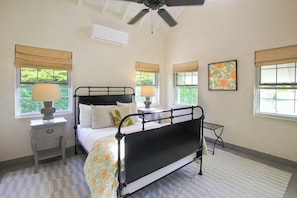 A bedroom with a bed, bedside tables, a ceiling fan, and windows with blinds. - Cowrie Cottage | Private Pool | Near Gibbes Beach (Gibbes)