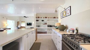 A modern kitchen with white cabinetry, a gas stove, and a central island. - Cowrie Cottage | Private Pool | Near Gibbes Beach (Gibbes)