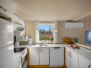 A modern kitchen with white cabinetry, a built-in oven, a microwave, and a sink. - "Ingalil" - 200m from the sea by Interhome (Løkken)