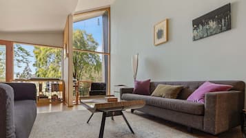 Una sala moderna con un sofá gris, una mesa de centro y una estantería.