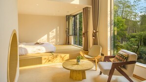 A modern bedroom with a large window, a bed, a chair, and a small table. - Haiyang Village Wildwood Resort Wuhan (Wuhan)