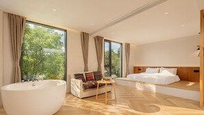 A modern bedroom with a large bathtub, a sofa, and a bed. - Haiyang Village Wildwood Resort Wuhan (Wuhan)