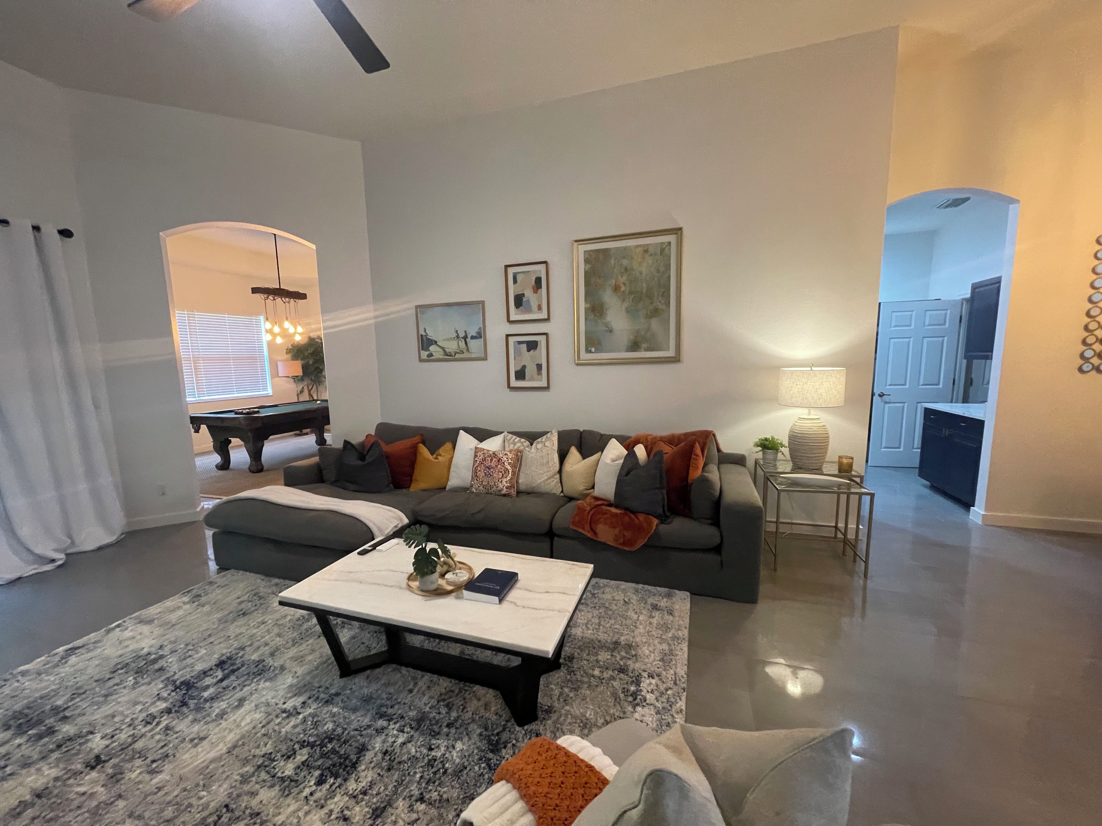 A living room with a sofa, coffee table, and artwork on the wall.