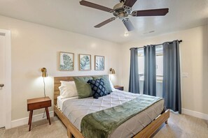 A bedroom with a bed, a nightstand, a ceiling fan, and a window with curtains. - Luxury Kanab Hot Tub - Trails & Pets OK (Kanab)