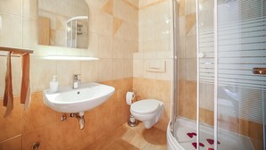 A bathroom with a sink, toilet, and shower.